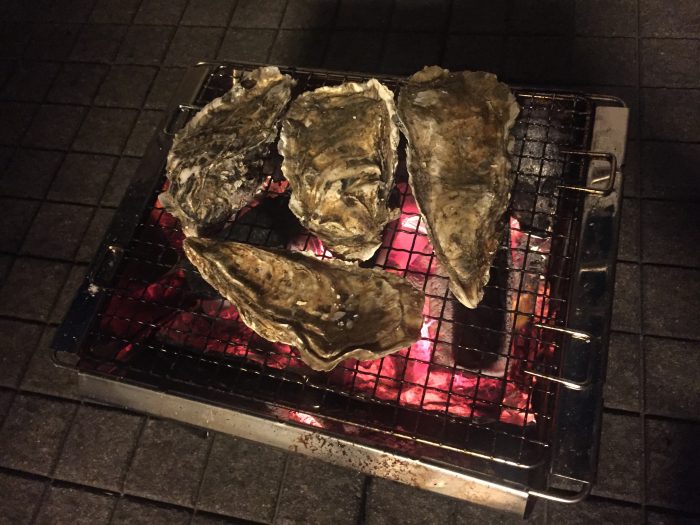 コンロに3Lサイズの生牡蠣を4つ並べて炭焼きしている